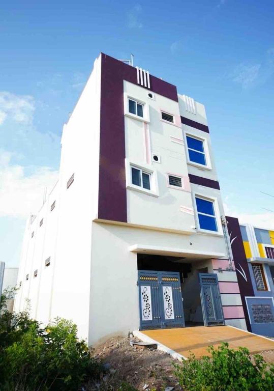 a white building with blue windows on the side of it at KUKAL CASTLE in Tiruppūr