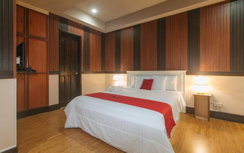 a bedroom with a large white bed with a red blanket at RedDoorz Plus at Canley Residential in Manila