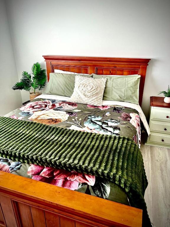 a bedroom with a large bed with a wooden frame at Sam's Cottage on Hennessey in Moe