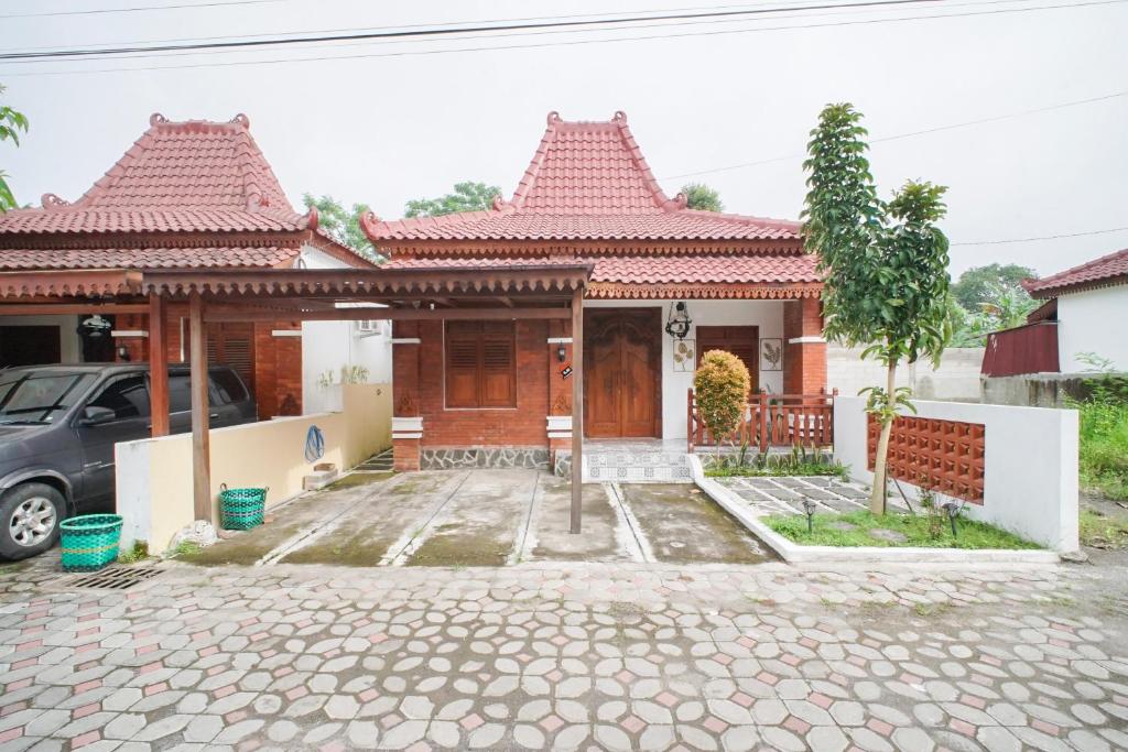 a house with a car parked in front of it at Joglo Prambanan B3 in Bugisan