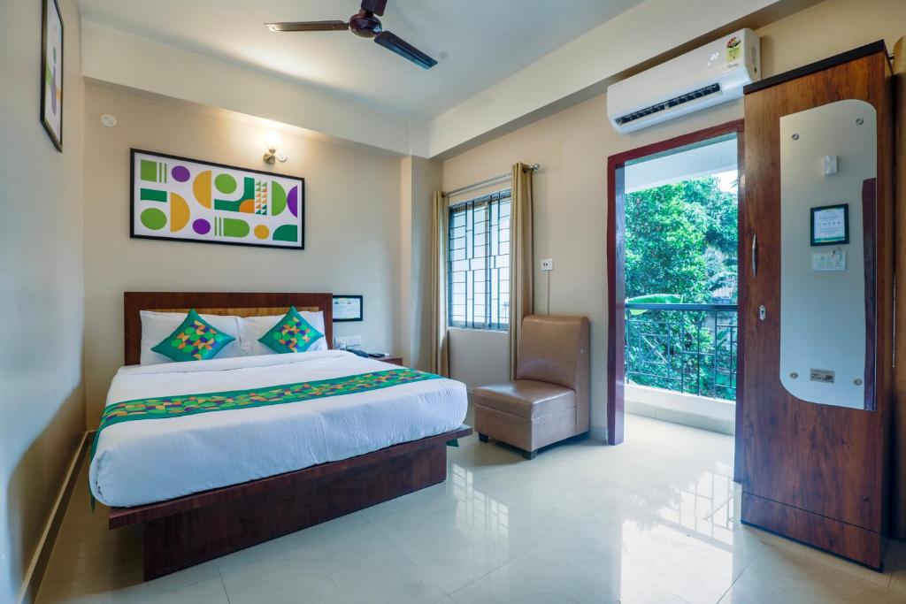 a bedroom with a bed and a sliding glass door at Treebo Urban Oasis Inn, Sixmile in Guwahati