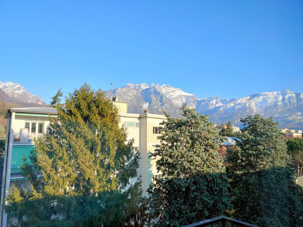a building with trees and mountains in the background at Apartment with a Mountain View in Lecco