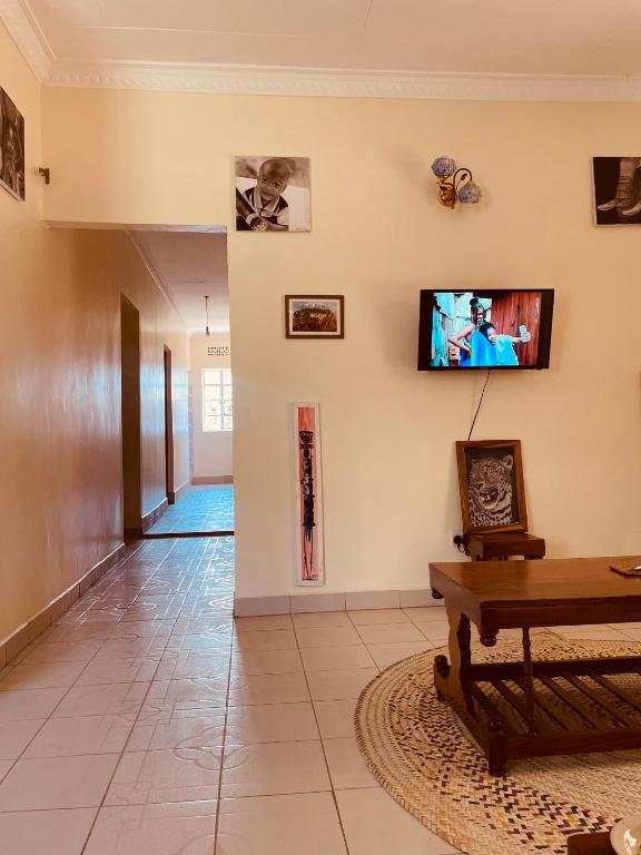 a living room with a flat screen tv on the wall at KidotuiVillaHome in Arusha