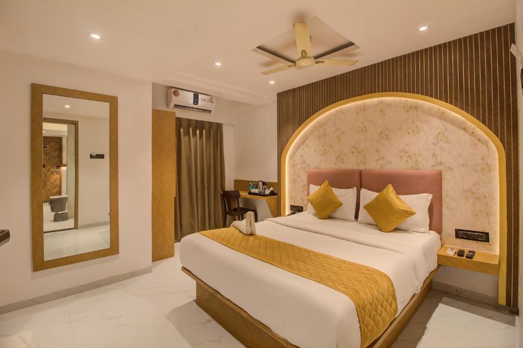 a bedroom with a large bed and a mirror at Hotel Malad Inn opposite Malad Railway Station in Mumbai