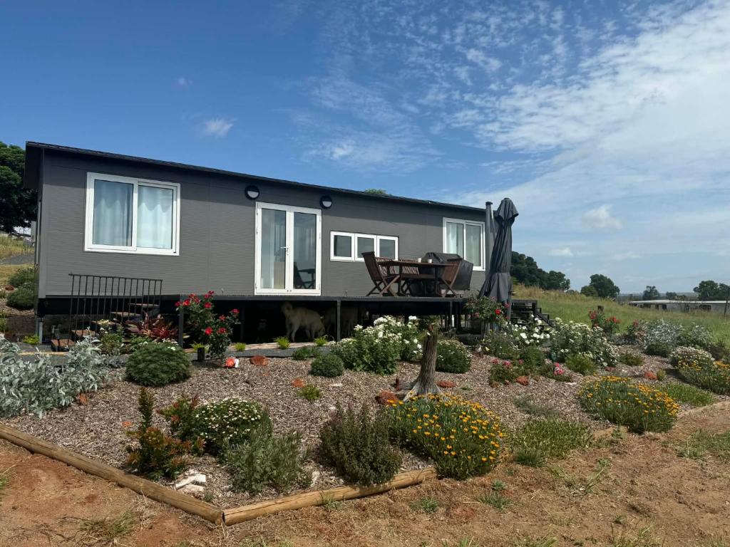 a house with a garden in front of it at Country Charm Cabins 2 Bedroom Tiny Home in Coolabunia