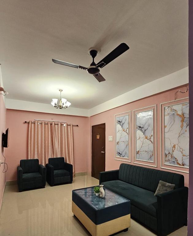 a living room with a couch and a ceiling fan at OhanaStay02 in Guwahati