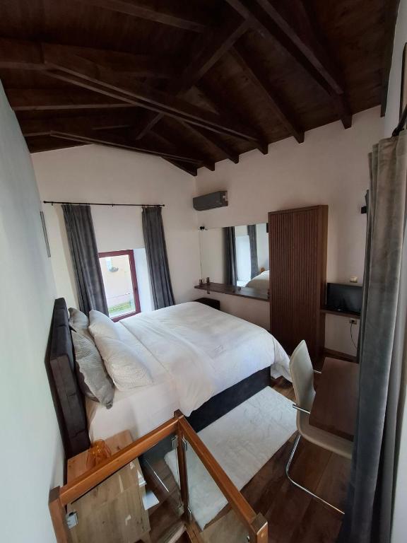 a bedroom with a large bed and a chair at Evanthia maisonette in Chalkida