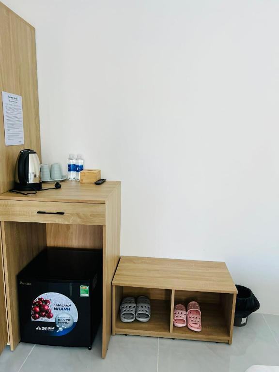 a small wooden table with shoes under it at GreenHotel in Ban M'drack