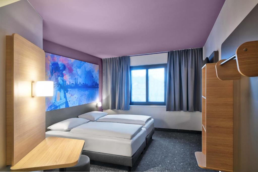a hotel room with a bed and a window at B&B HOTEL Kassel-Wilhelmshöhe in Kassel
