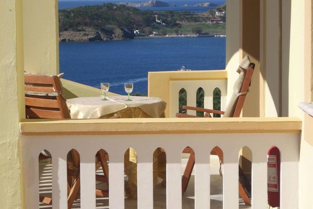 a balcony with a table and two glasses of wine at Melina's sunset-Cozy studio with amazing sea view and sunset in Myrties
