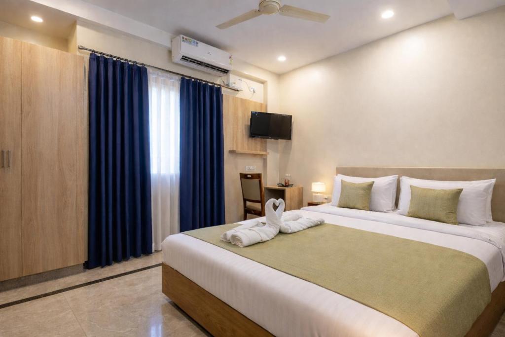 a bedroom with a large bed with a towel on it at Hotel Chalet, Madiwala in Bangalore