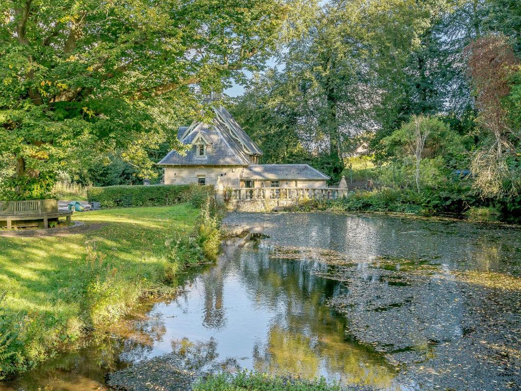 a house next to a river in front of a building at East Lodge in Falkland