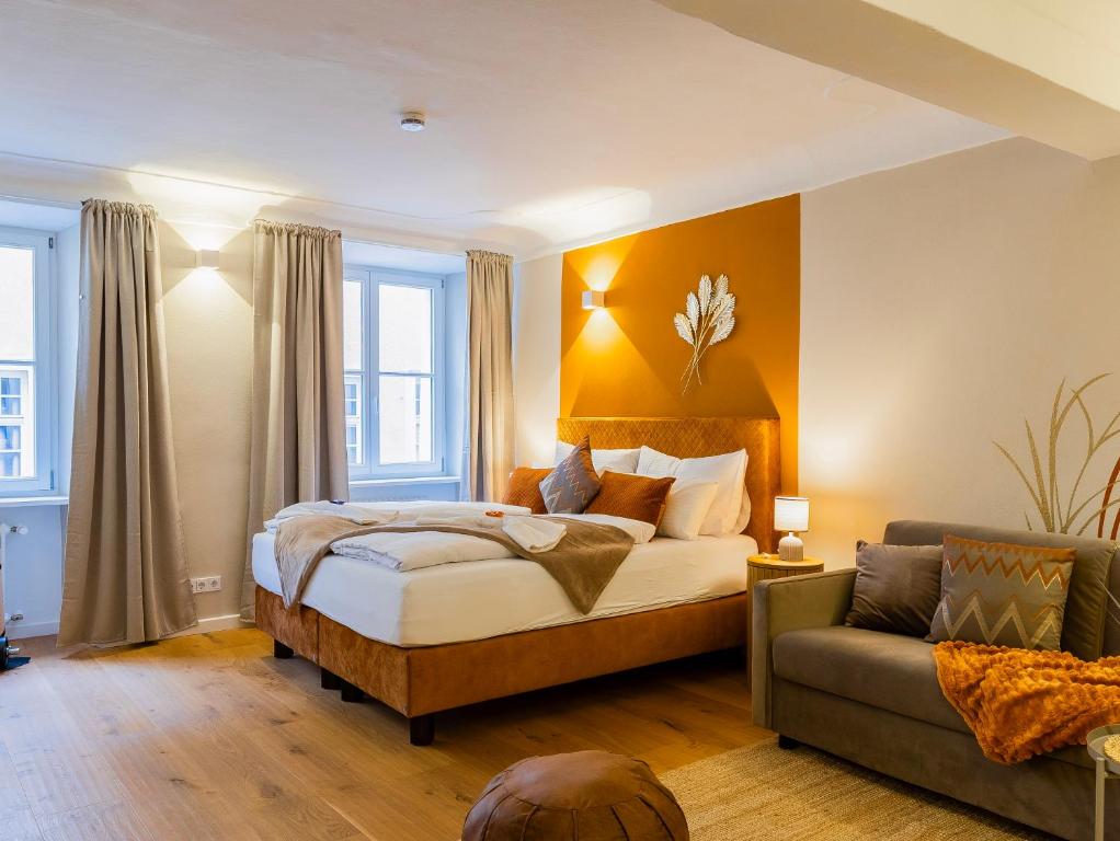 a bedroom with a bed and a couch at Altstadt Loft XL I 90 qm I 2 Schlafzimmer I 2 Arbeitsplätze I 6 Gäste in Passau