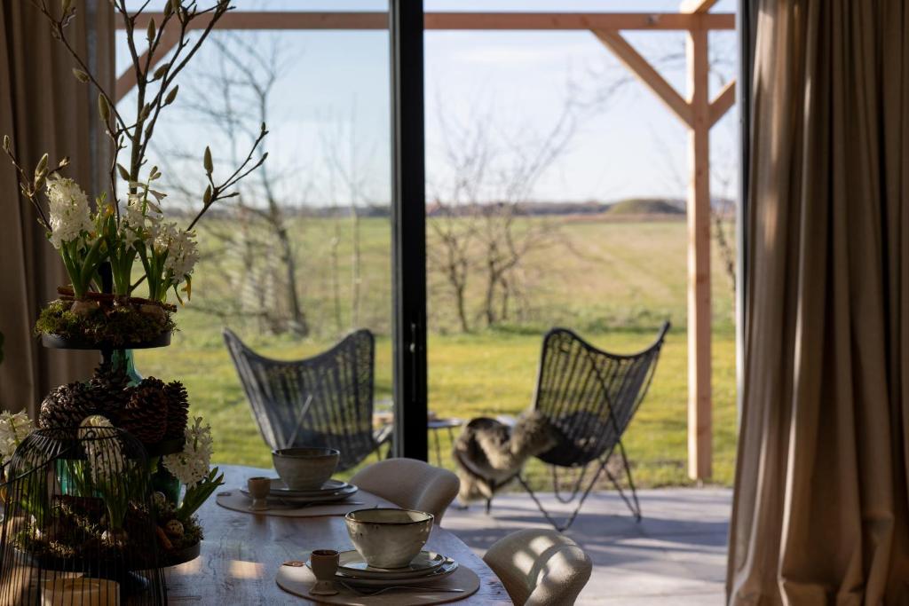 a table with chairs and a view of a field at Slapen bij Bioduin in Koudekerke