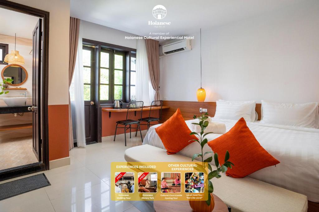 ein Hotelzimmer mit einem Bett mit orangefarbenen Kissen in der Unterkunft First Hoianese Center Hotel - Cultural Experiential Hotel in Hoi An