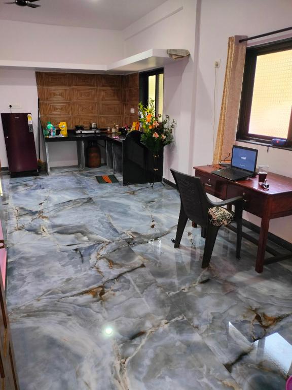 a room with a marble floor with a desk and a laptop at Tree hugs mandrem in Mandrem