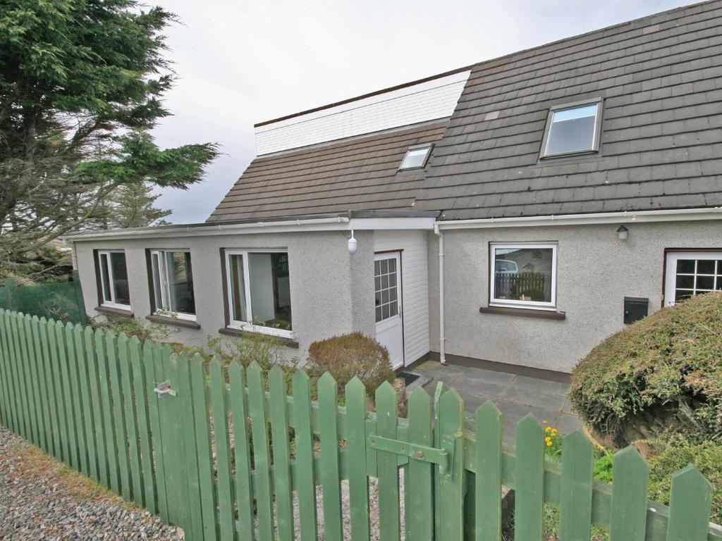 a house with a green fence in front of it at Ken Maree in South Erradale