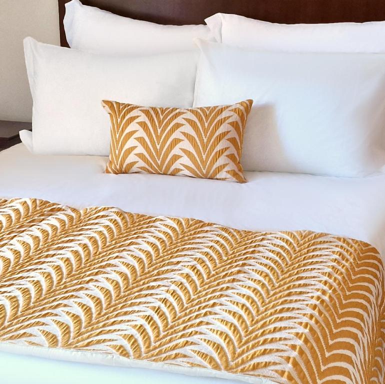 a bed with white sheets and pillows on it at Hotel Vale Do Côa in Vila Nova de Foz Coa