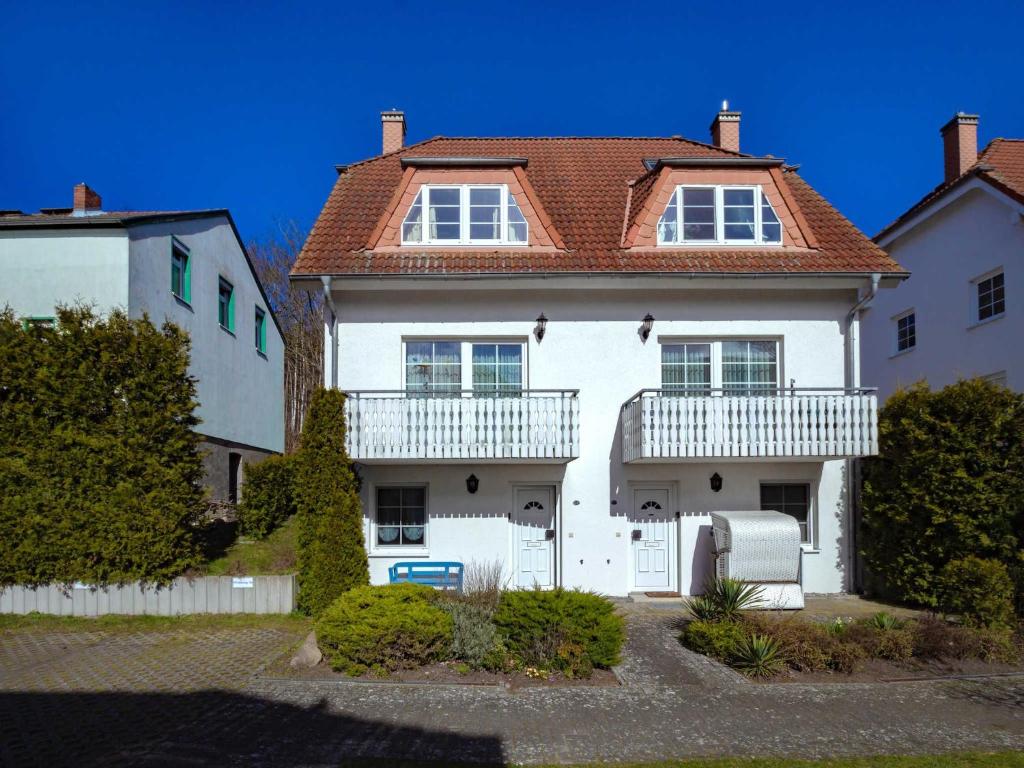 a white house with a red roof at Fährhaus Sellin - Ferienwohnung 2 in Ostseebad Sellin