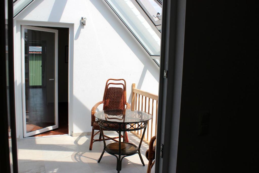 a table and a chair on a balcony at Ostseepension TonArt in Mechelsdorf