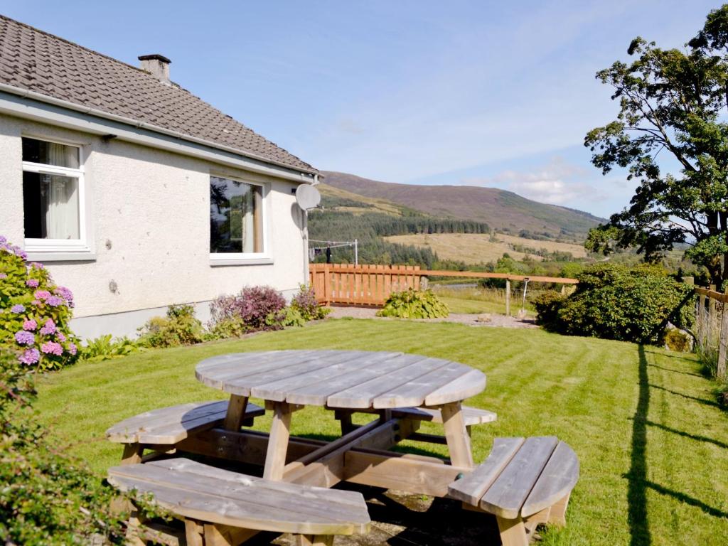a wooden picnic table in the yard of a house at Strone Farm House in Torcastle