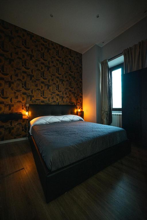 a bedroom with a bed and a brick wall at Chivasso centro - Garden Apartments in Chivasso