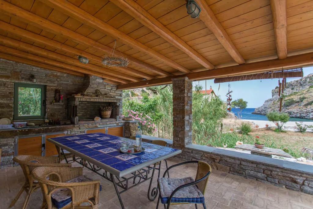 a patio with a table and chairs and a kitchen at villapetramarina in Tsakaíoi