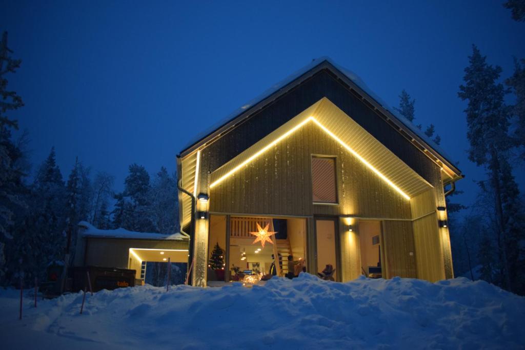 a house with a star on the front of it at night at Levi Lakeview Ahvenranta in Kittilä