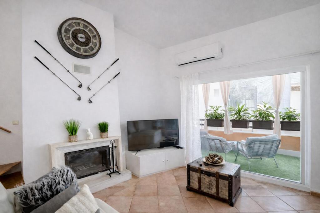 a living room with a fireplace and a clock on the wall at Lo Exclusive Lisboa - Apartament with terrace and golf view in Charneca