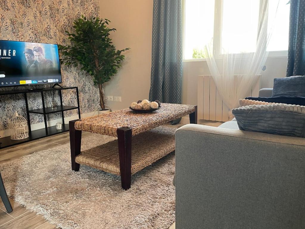 a living room with a coffee table and a tv at Vert Bocage à Bâlines in Balines