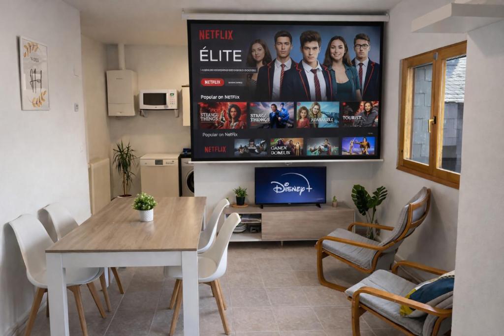 a living room with a table and a tv at Apto Espert l PISCINA l Cine l Garaje l BBQ l Wifi in Biescas
