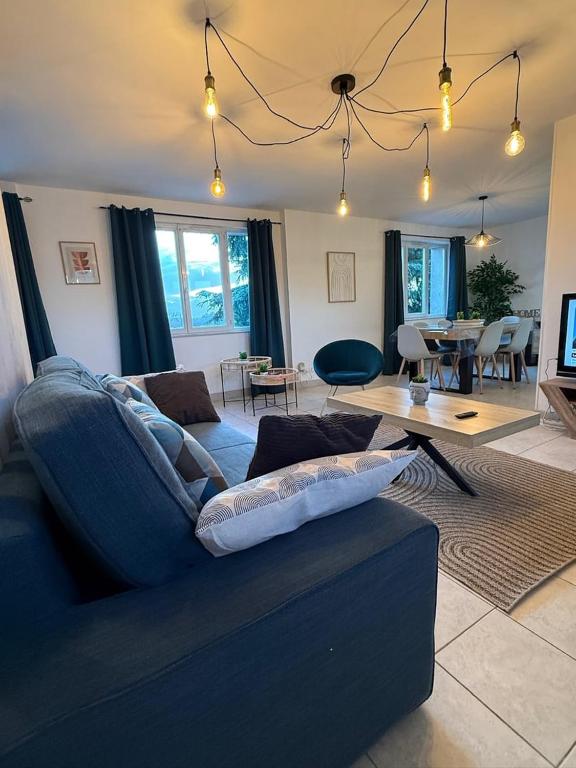a living room with a blue couch and a table at Grand T3 2 chambres avec vue sur la campagne à Bâlines in Balines