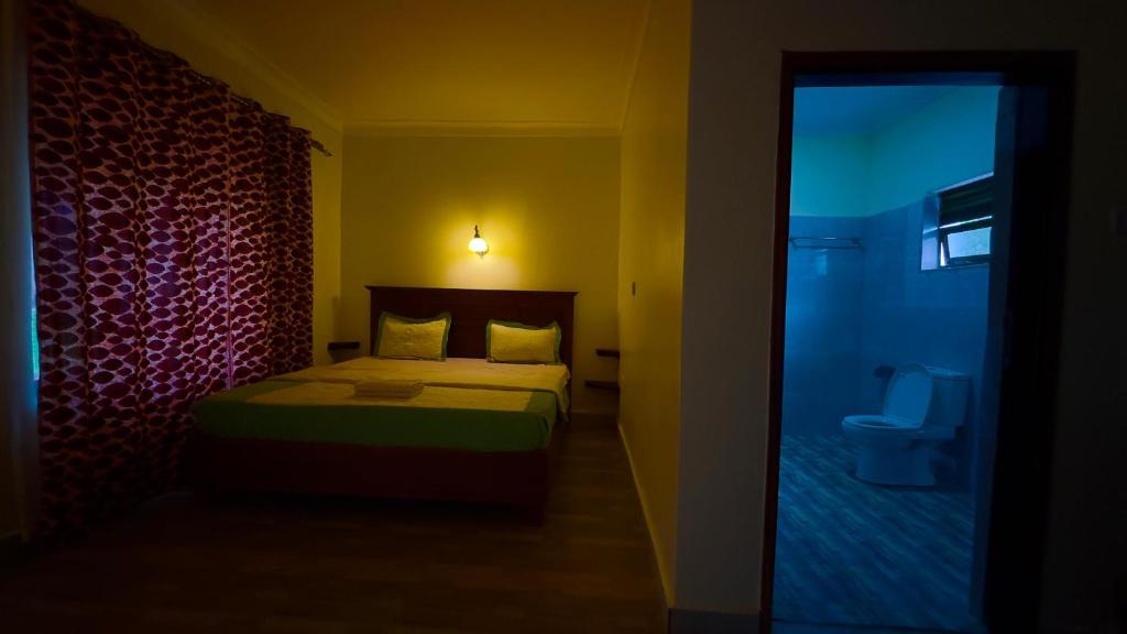 a small bedroom with a bed and a toilet at Karibu Resort Sipi in Kapchorwa