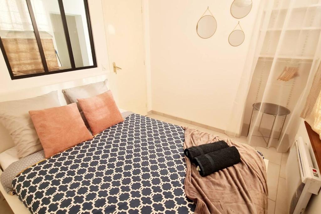 a bedroom with a bed with a blue and white comforter at Appart' Lumineux & Chic. Parking Rue Sans Stress in Dreux