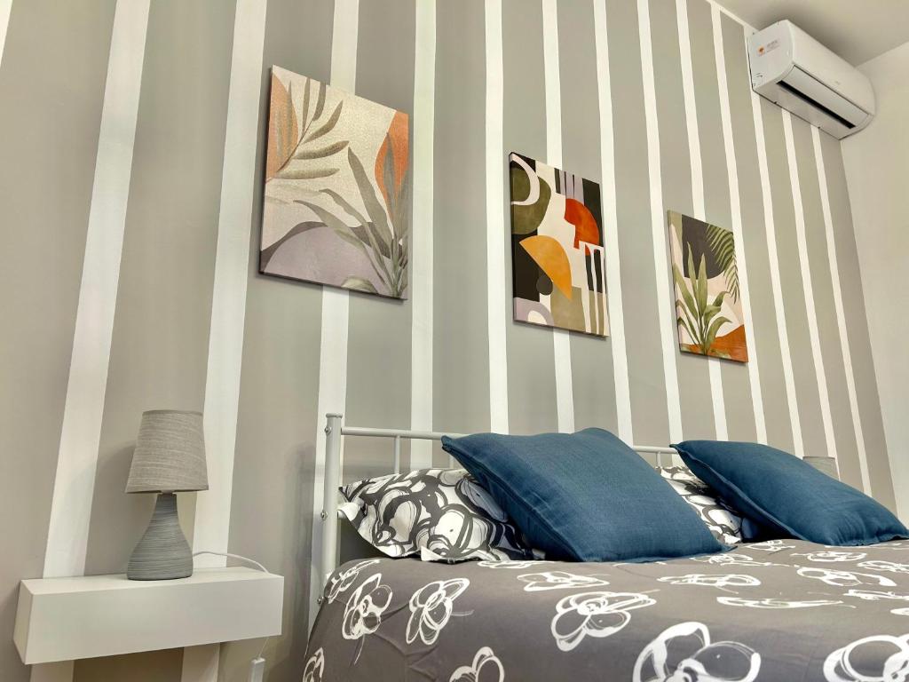 a bedroom with a bed with a striped wall at Casa Verdi in Corleone