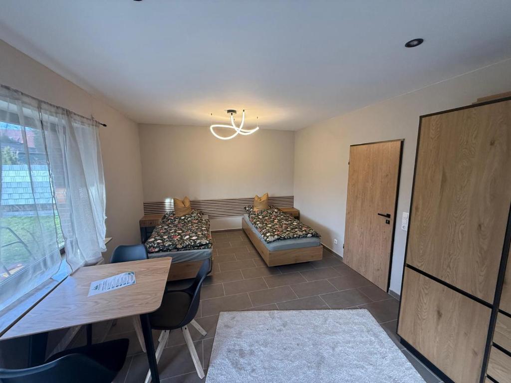 a room with three beds and a table and a window at stayOldenburg in Oldenburg