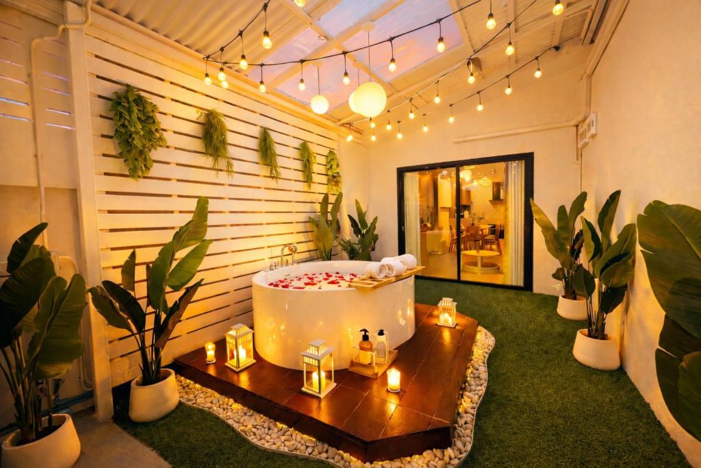 a room with a bath tub and plants and lights at Villa Luna and Villa Solara in Koh Samui
