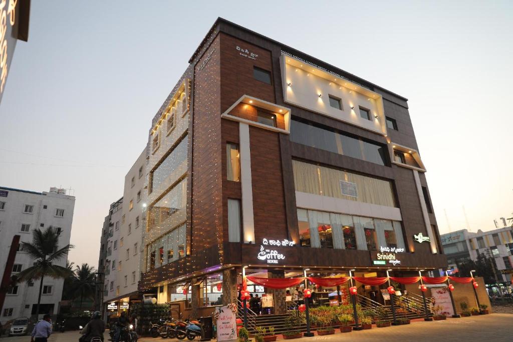 a tall building with a restaurant in front of it at The White Pearl Suites in Bangalore