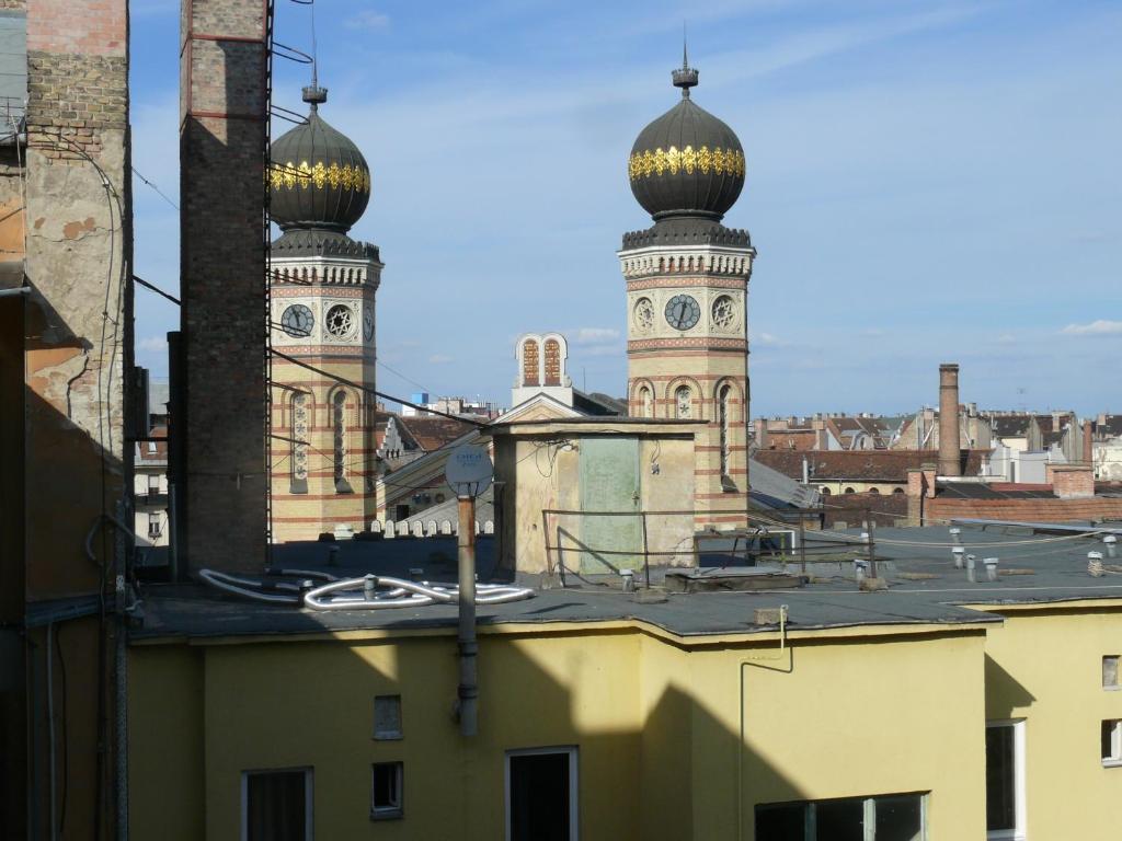ブダペストにあるDiamond Astoria Apartmentsの屋根付きの建物の上に二つのドーム