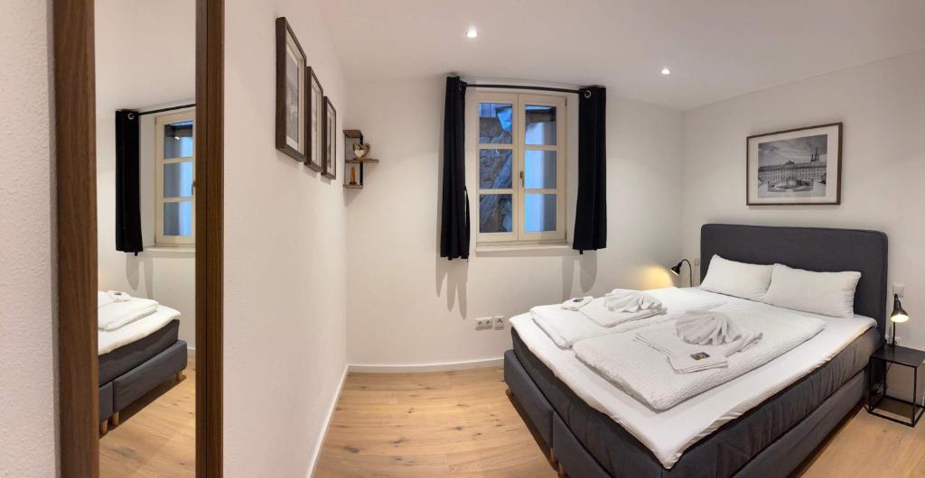 a bedroom with a large bed and a mirror at Juraperle - Historisch und modern - Wohnung 1 in Bad Staffelstein
