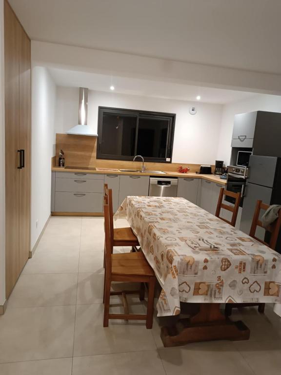 a kitchen with a table and chairs and a television at Gite du Châtelard in Thiébouhans