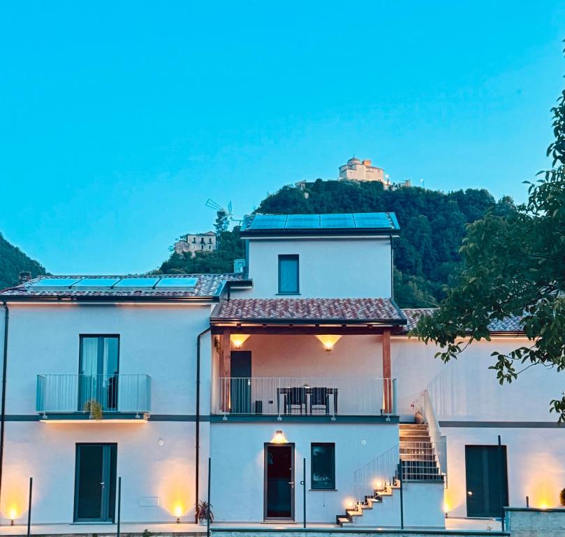 a white house with a hill in the background at VicoLetto Bed and Breakfast in Laino Borgo