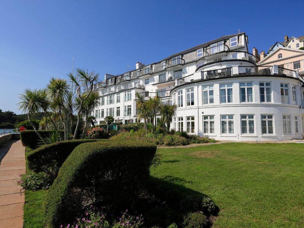 a large white building with palm trees in front of it at 3 The Salcombe in Salcombe
