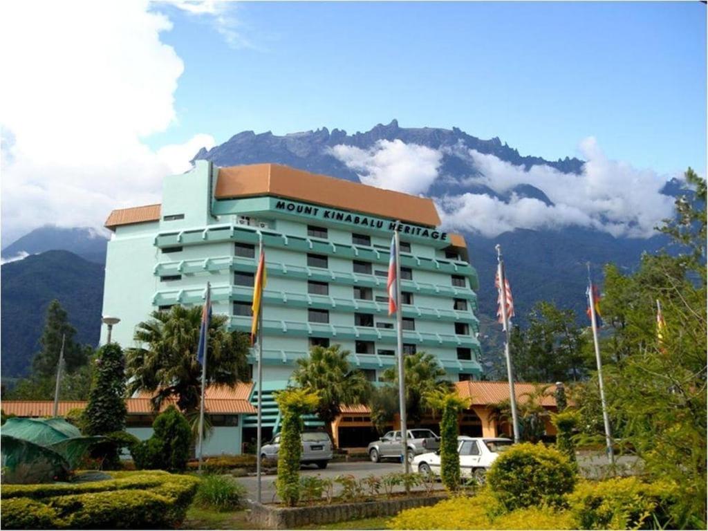 a hotel with cars parked in front of a building at Perkasa Mt Kinabalu , Sabah in Kampong Kundassan