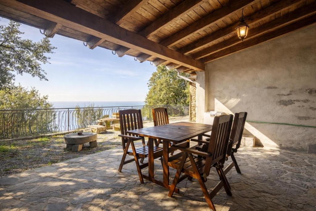 a table and chairs on a patio with a view of the ocean at Altamarea Private Retreat in Corniglia
