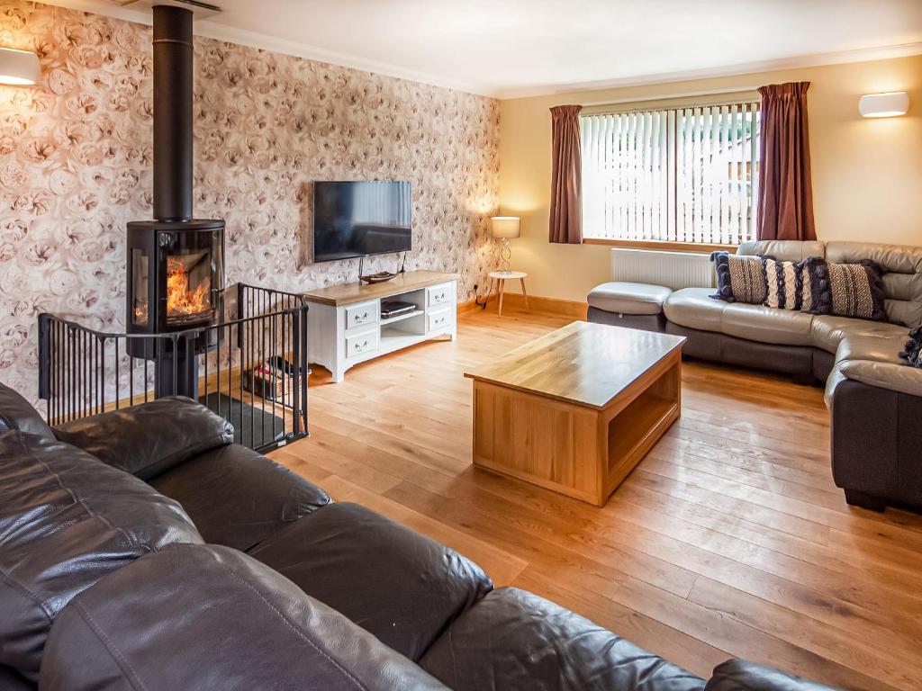 a living room with a couch and a fireplace at Beinn View House in Cononbridge