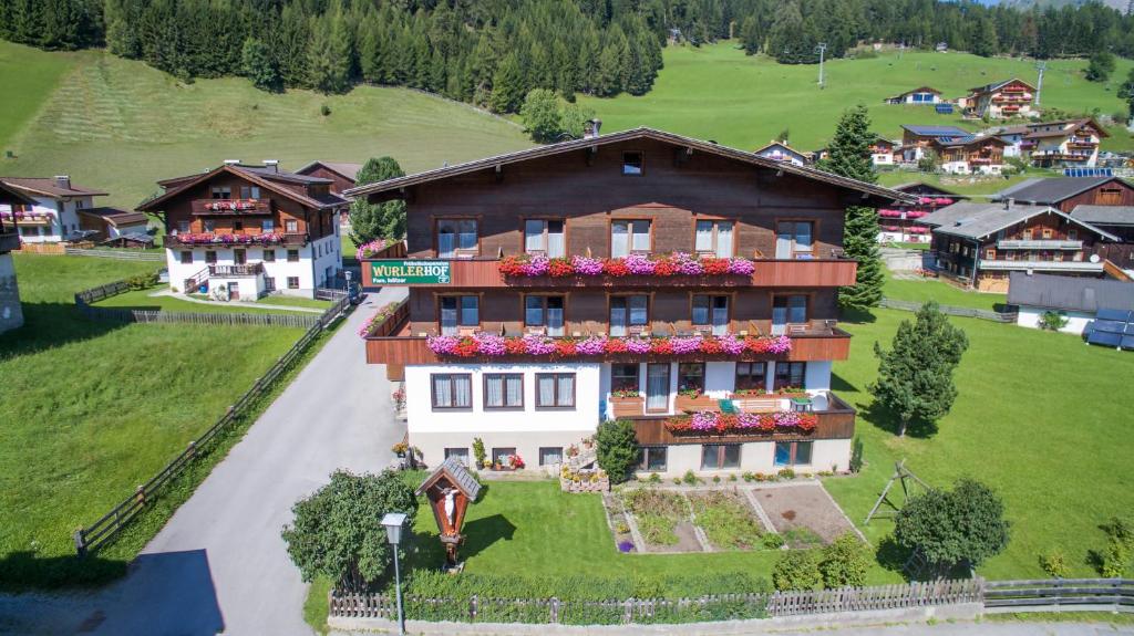 una casa grande con flores en la parte delantera en Wurlerhof, en Kals am Großglockner