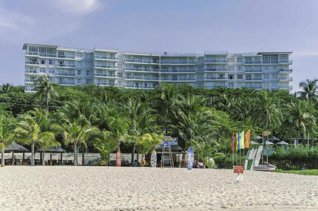 a sandy beach with a large building in the background at Căn Hộ OceanVista & Biệt Thự Sealink Phan Thiết - Mũi Né in Phan Thiet