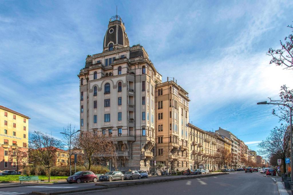 a tall white building with a tower on a street at The Place in Milan