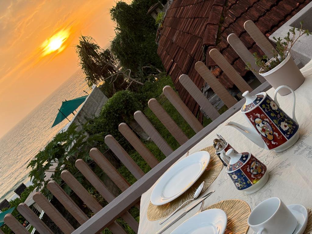 a table with plates and mugs on top of it at Villa Nature Glee in Dodanduwa